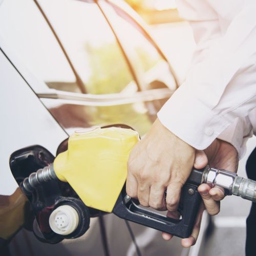 Man putting gasoline fuel into his car in a pump gas station