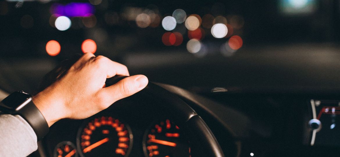 Young man driving his car at a night time